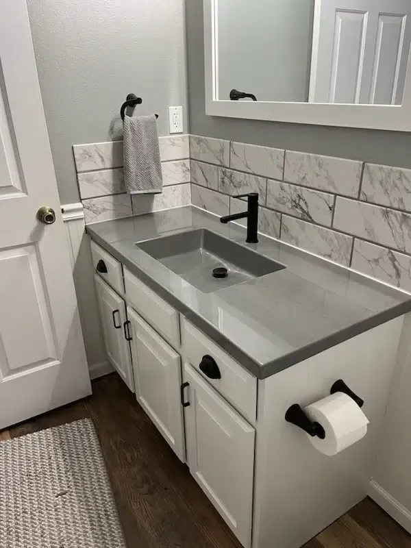 A bathroom with a sink , mirror , and towel rack.