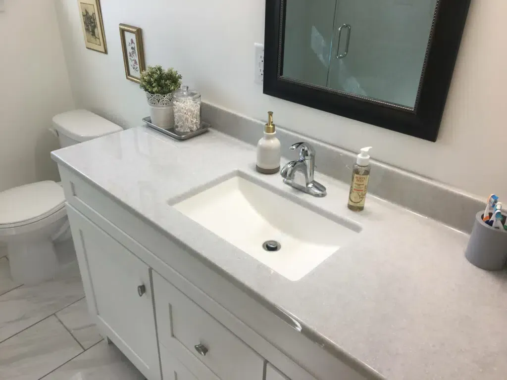 A bathroom with a sink , toilet and mirror.