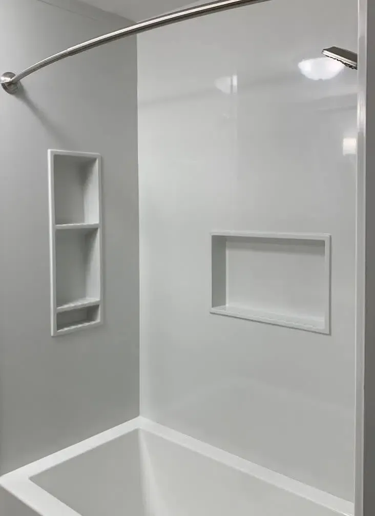 There is a bathtub in the shower with a shower head.