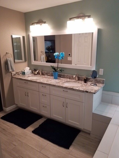 A bathroom with two sinks and a large mirror