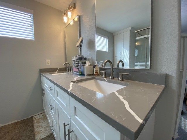 A bathroom with two sinks and a large mirror.