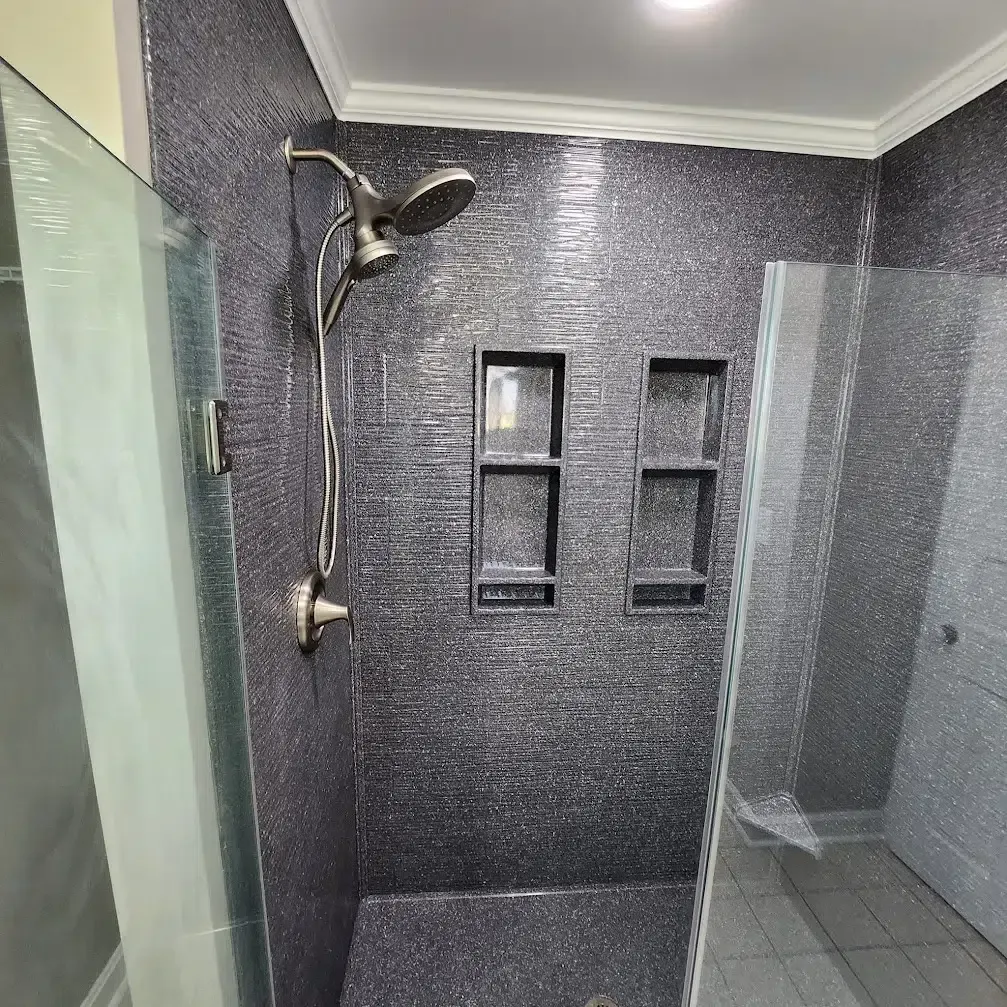 There is a shower with a glass door and a shower head.