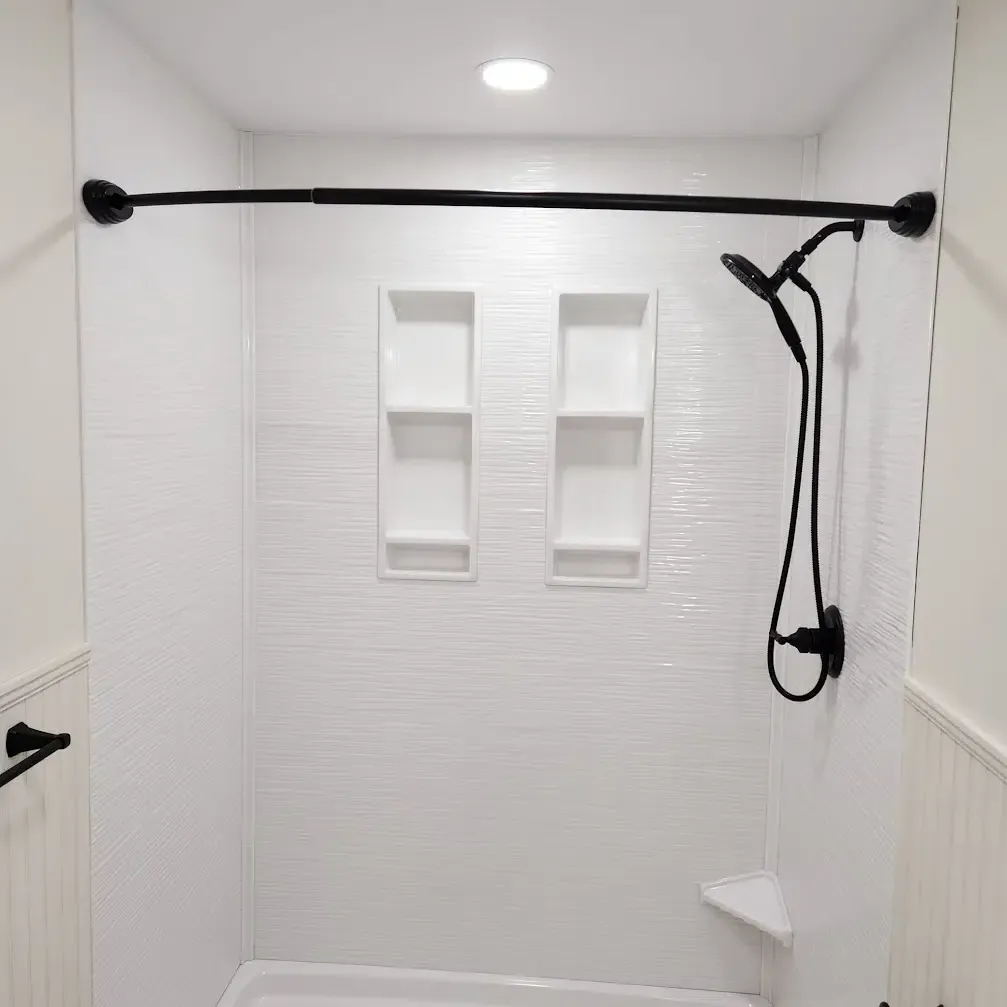 A white shower with a black shower head