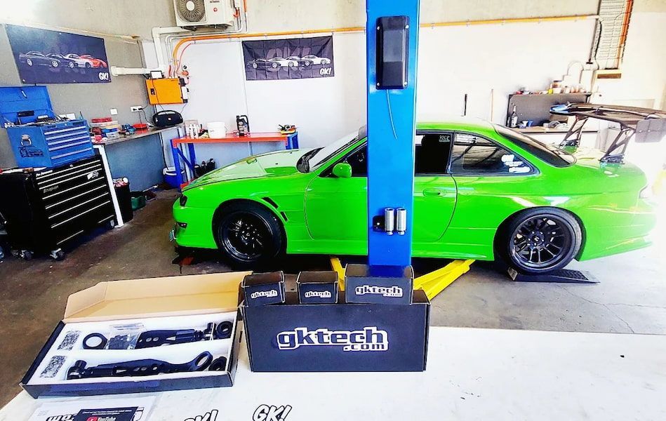 A Green Car Is on A Lift in A Garage — Wilkomotive Mechanical in Bentley Park, QLD