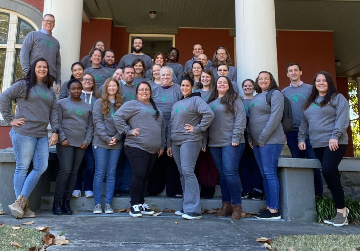 CFO Network Cares team are posing for a picture on the steps of a building.