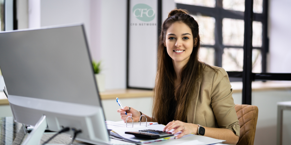 A woman is sitting at a desk in front of a computer at cfo network