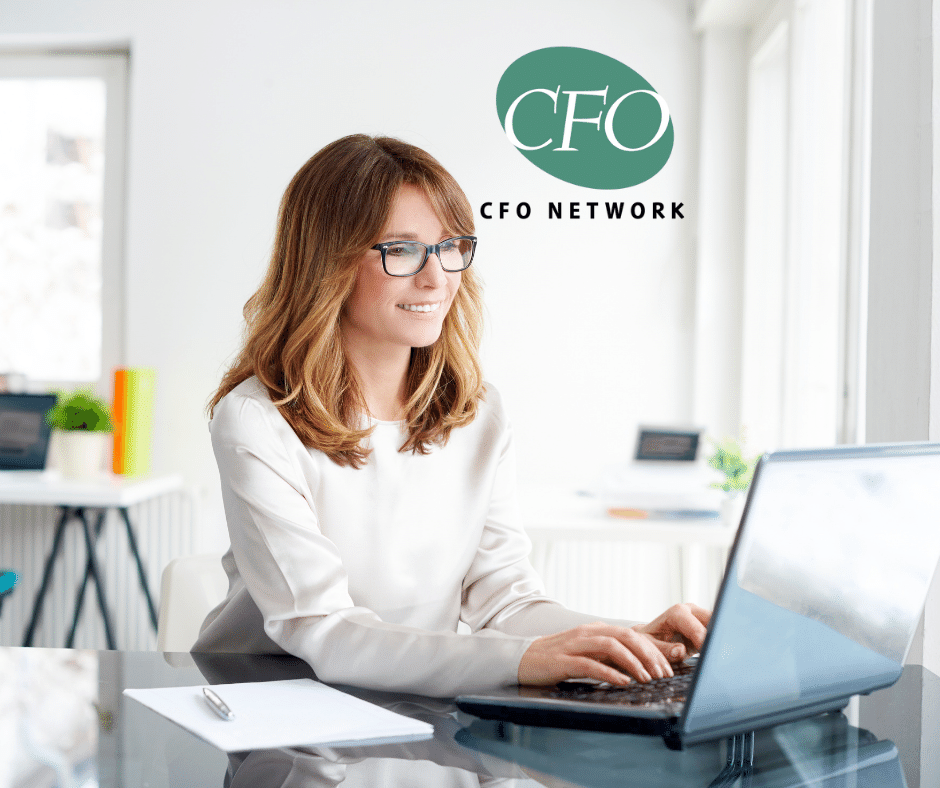 A woman is sitting at a desk using a laptop computer studying a financial graph at CFO Network in North Little Rock, Ar