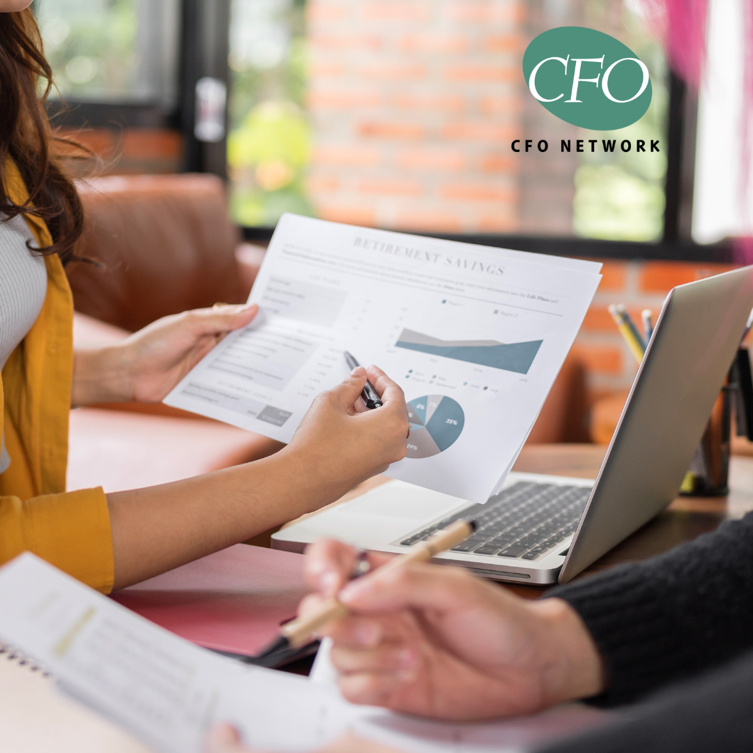 A woman is holding a piece of paper that is evaluating the sale of a business. 