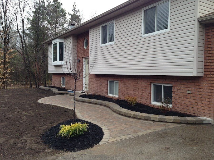 A brick house with a walkway leading to the front door.