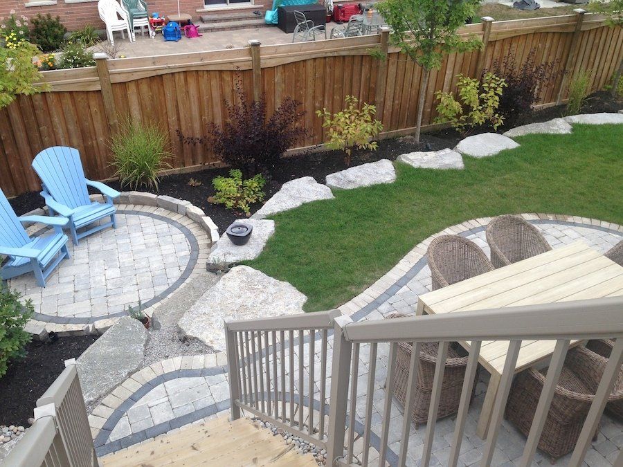 A backyard with a table and chairs and a wooden fence