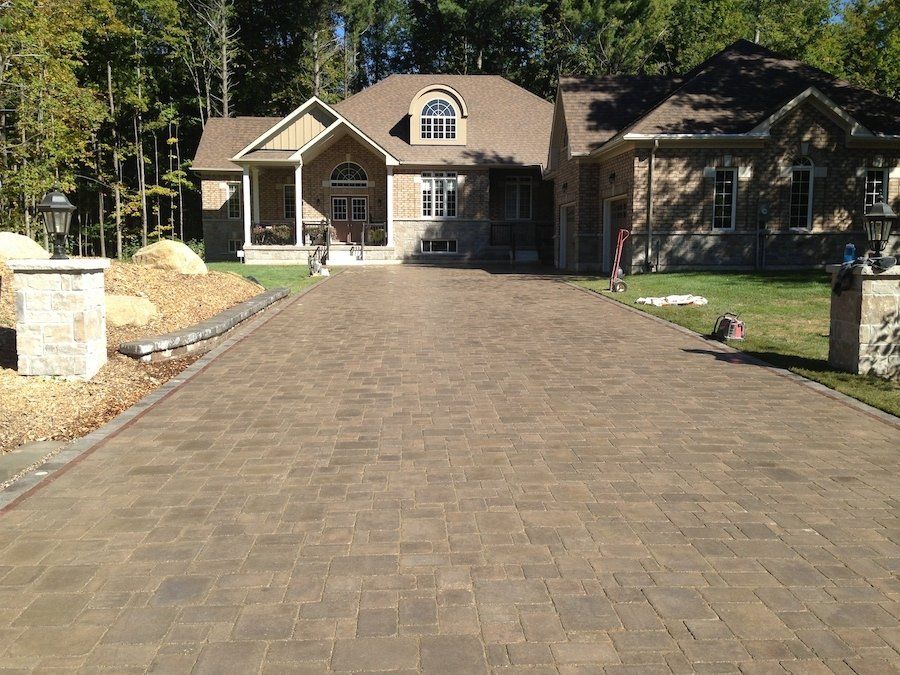 A large house with a brick driveway leading to it