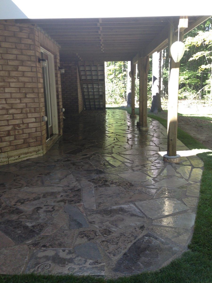 A stone patio with a brick building in the background