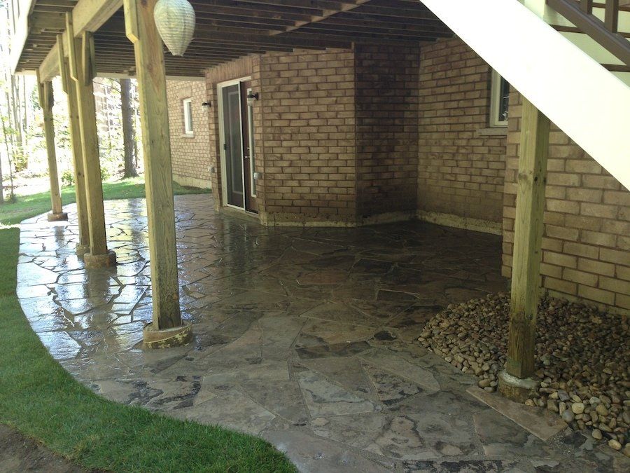 A brick building with a stone walkway underneath it