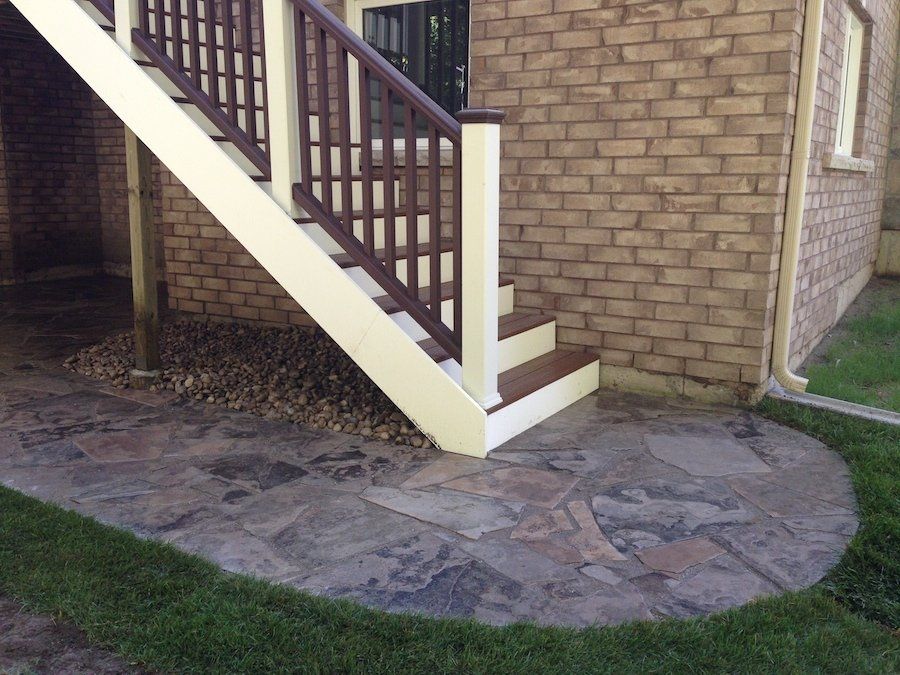 A brick house with stairs leading up to the second floor