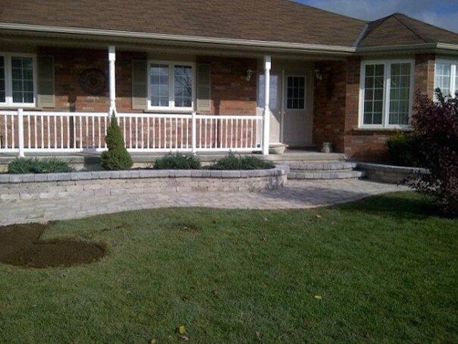 A brick house with a white railing and steps
