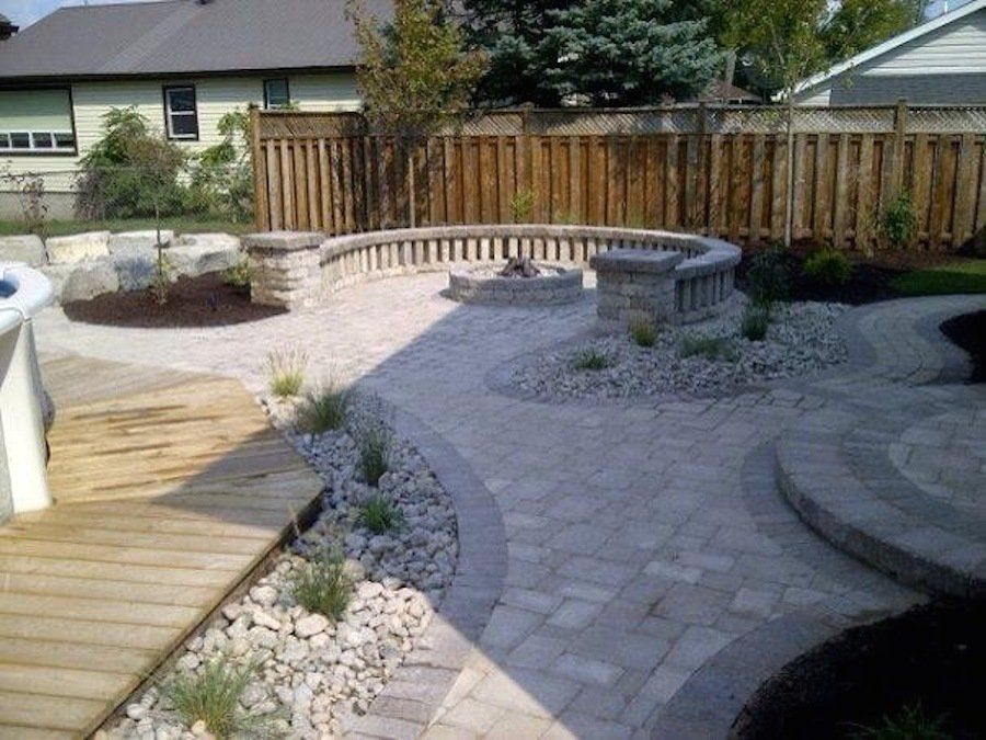 A backyard with a fire pit and a wooden fence