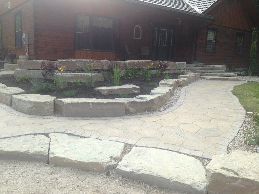 A brick house with a stone walkway leading to the front door.