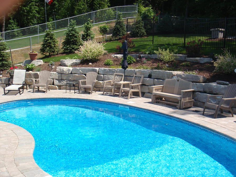 A large swimming pool with chairs and tables around it