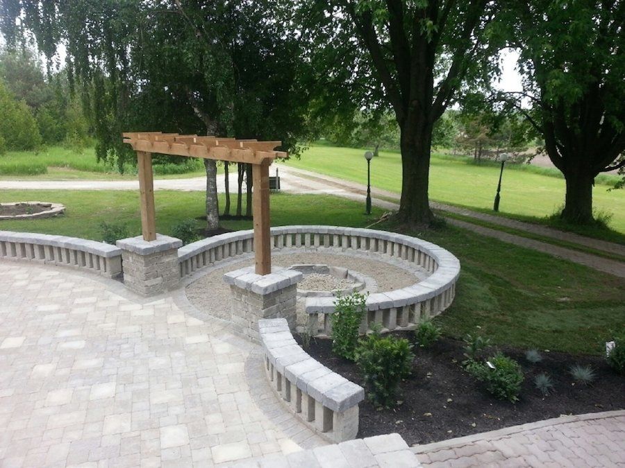 A patio with a wooden pergola and a bench