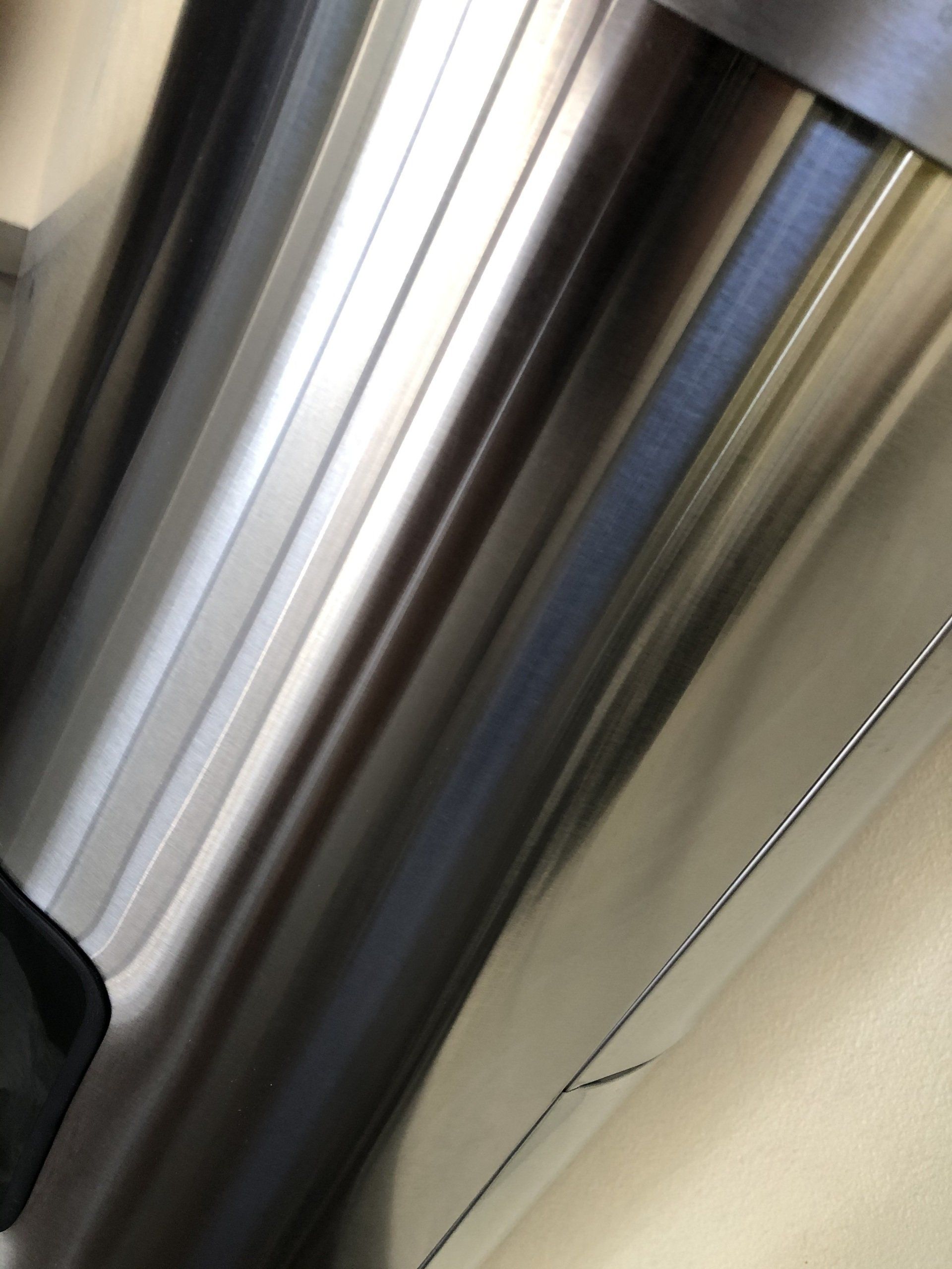 Shiny, metallic surface with parallel ridges and subtle reflections.