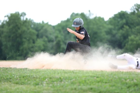 Youth baseball player sliding into a base