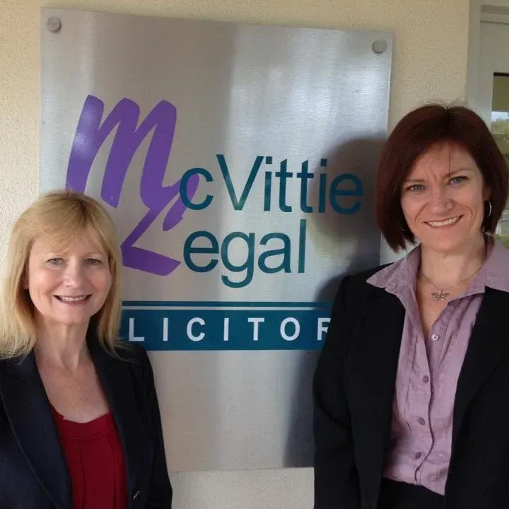 The owners standing in front of McVittie Legal sign — McVittie Legal In Ballina, NSW