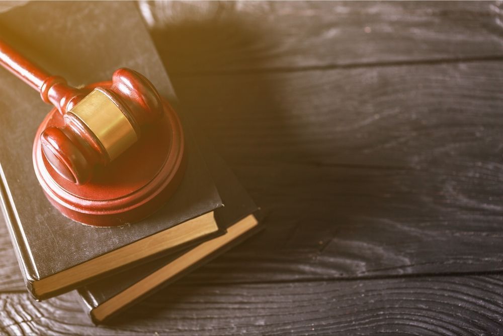 Wooden gavel resting on a law book on a dark wooden surface — McVittie Legal In Ballina, NSW
