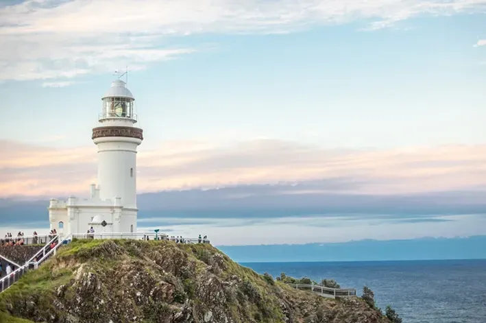 A Lighthouse On a Headland Overlooking the Ocean At Byron Bay  — McVittie Legal In Ballina, NSW
