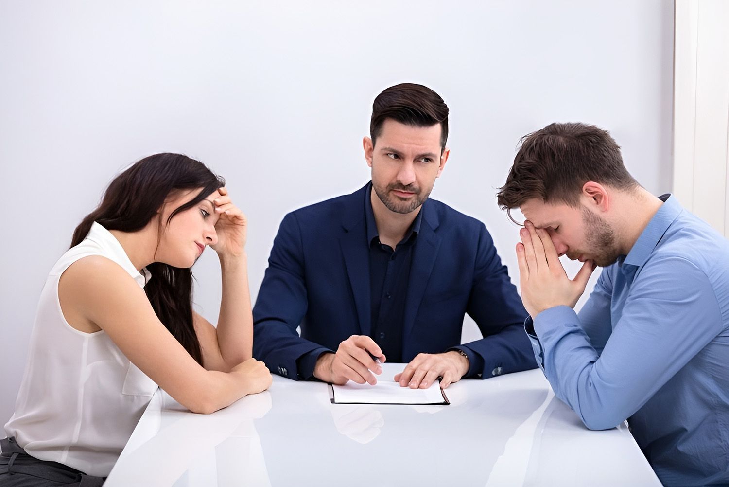 Couple At Table With Lawyer, Looking Distressed