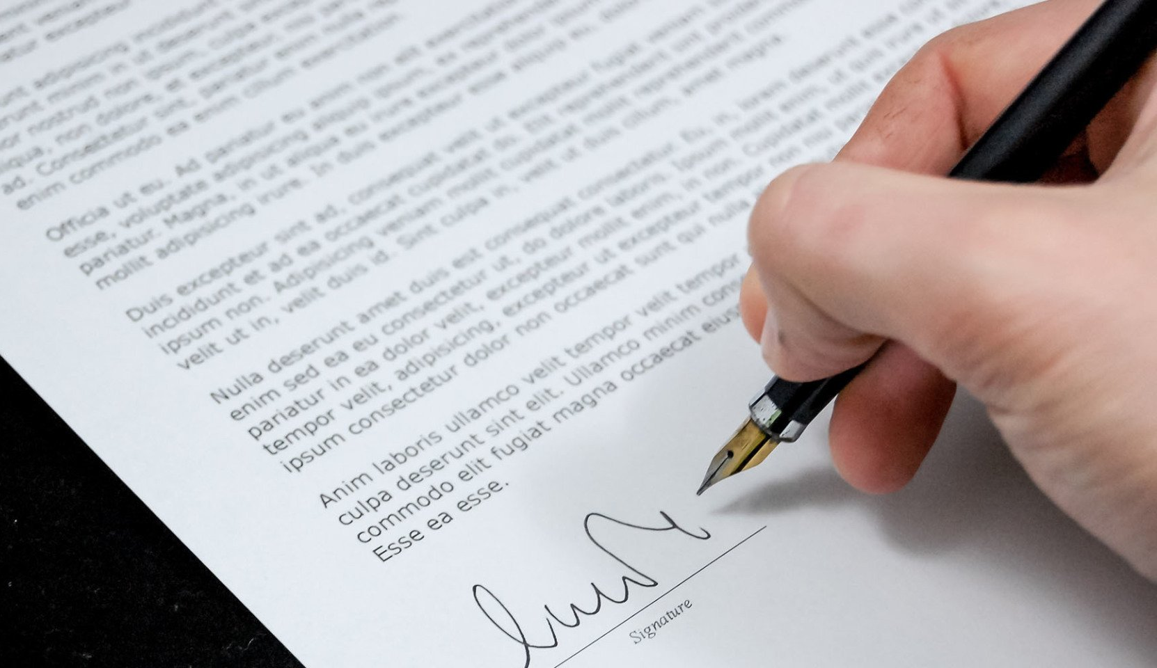 Signing a funeral plan with a fountain pen