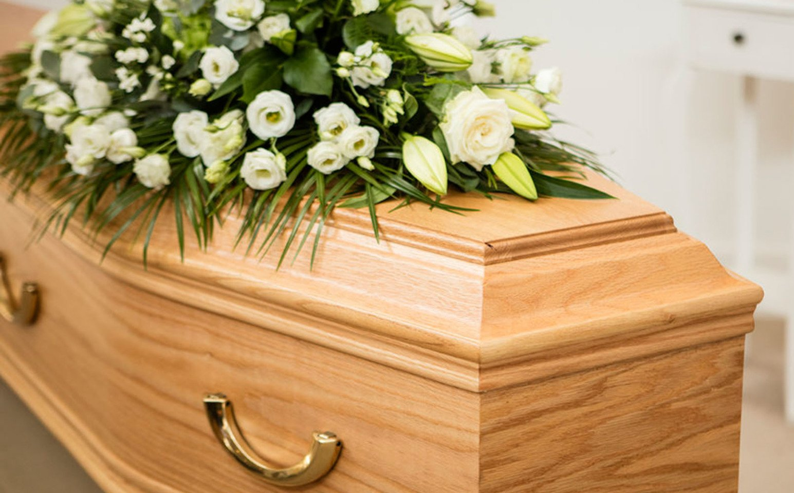 coffin with yellow flowers on top, funeral director in burnham,  weston