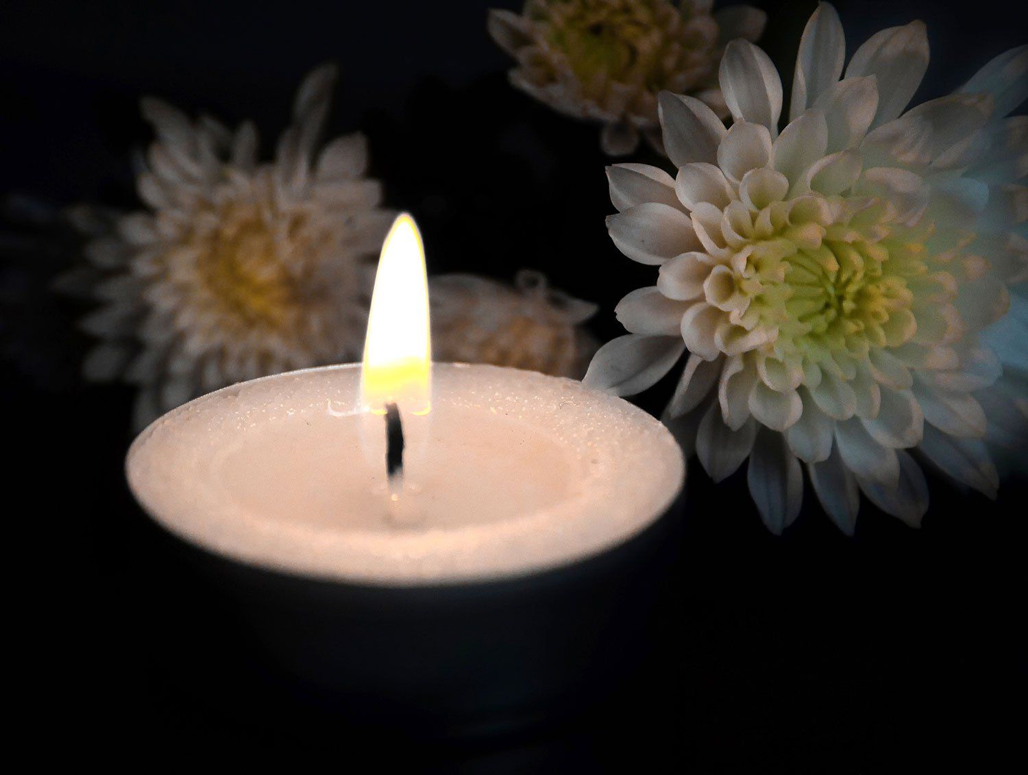 single lit candle with flowers in the background, aj lock, funeral services, weston, burnham