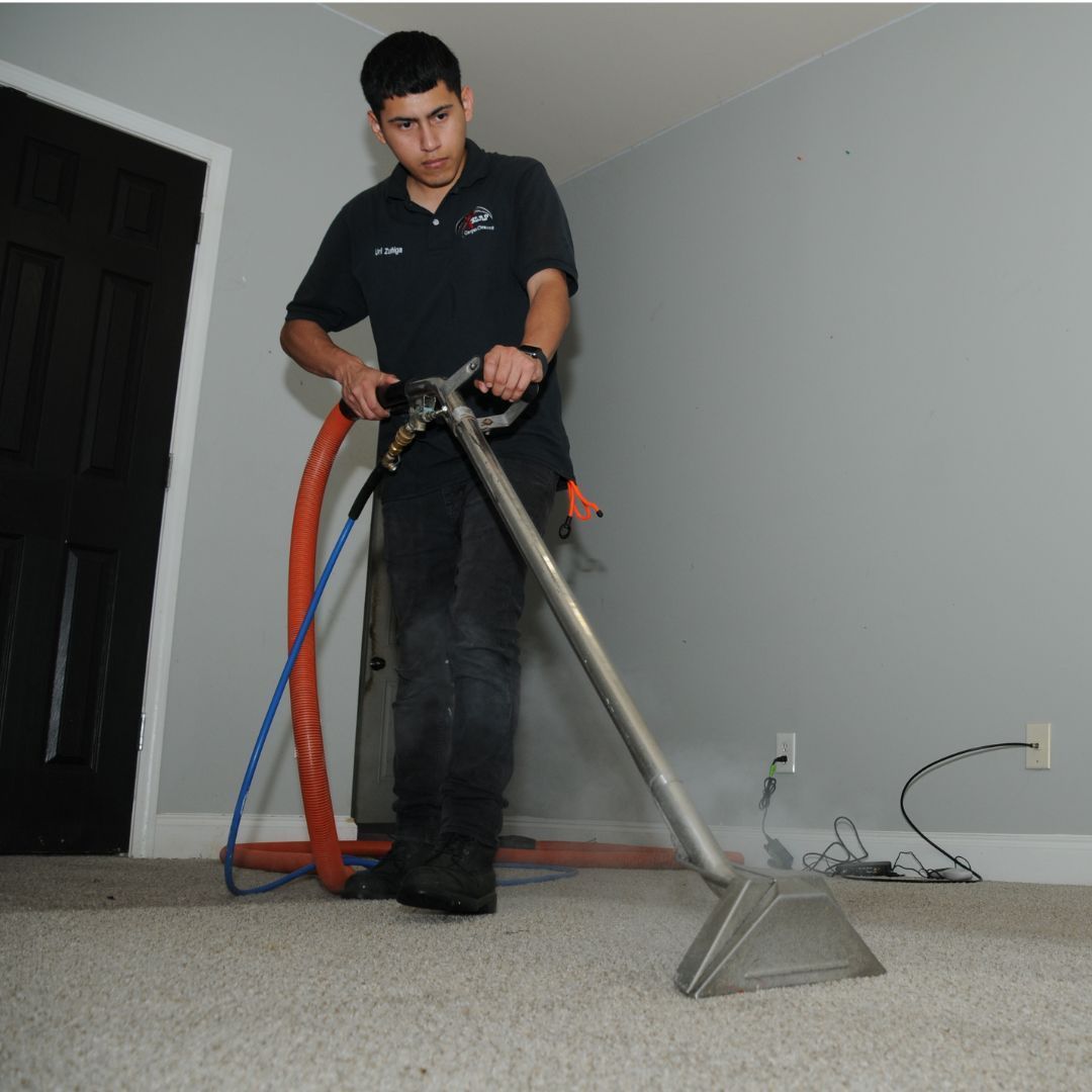 Professional cleaning technician performing steam carpet cleaning service.