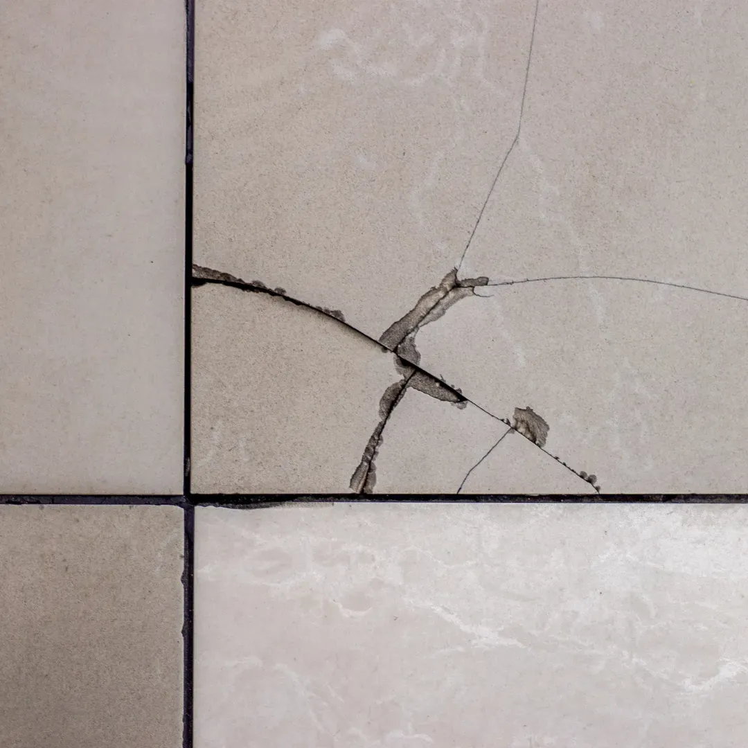 Cracked tile floor being repaired.