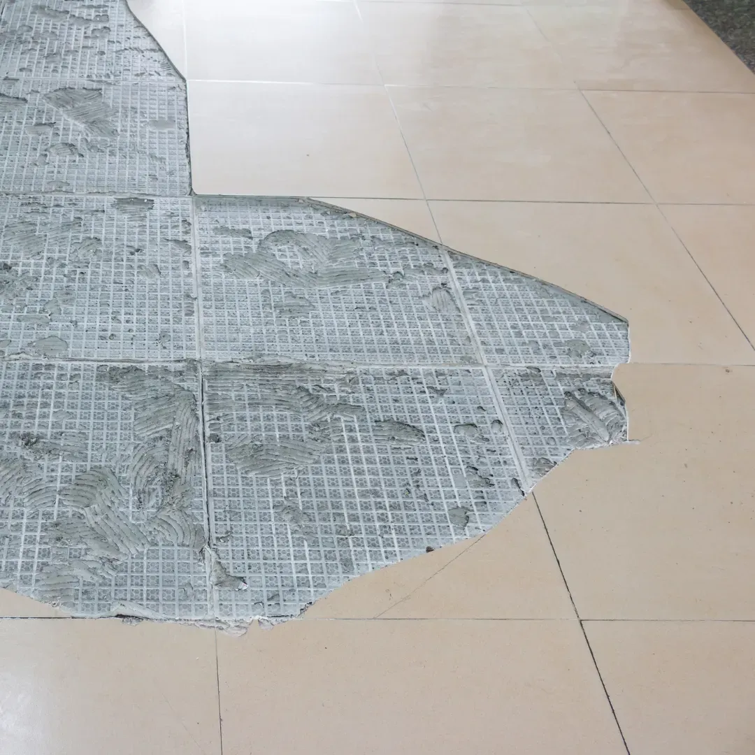 Damaged ceramic tile flooring being repaired.