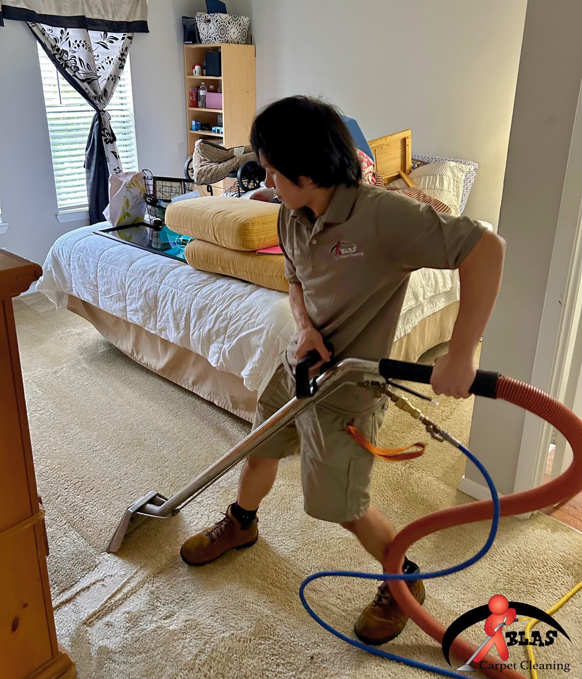 Professional steam carpet cleaning technician removing stains from residential carpeting in Atlanta, Georgia.