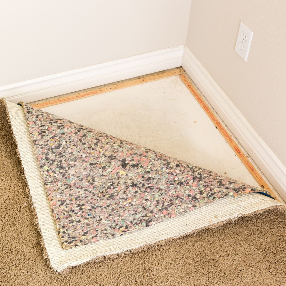 Carpet installation specialist replacing old padding.