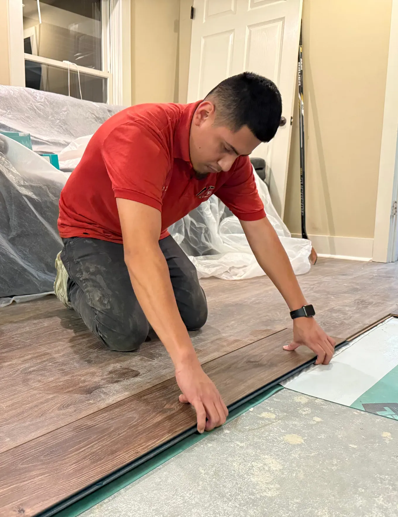 Vinyl plank flooring installation specialist working.