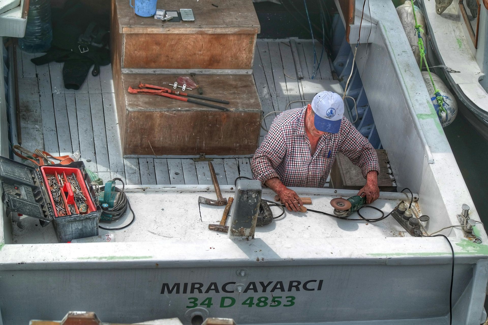 A man is working on a boat with mirac ayarci 34 d4853 on the back