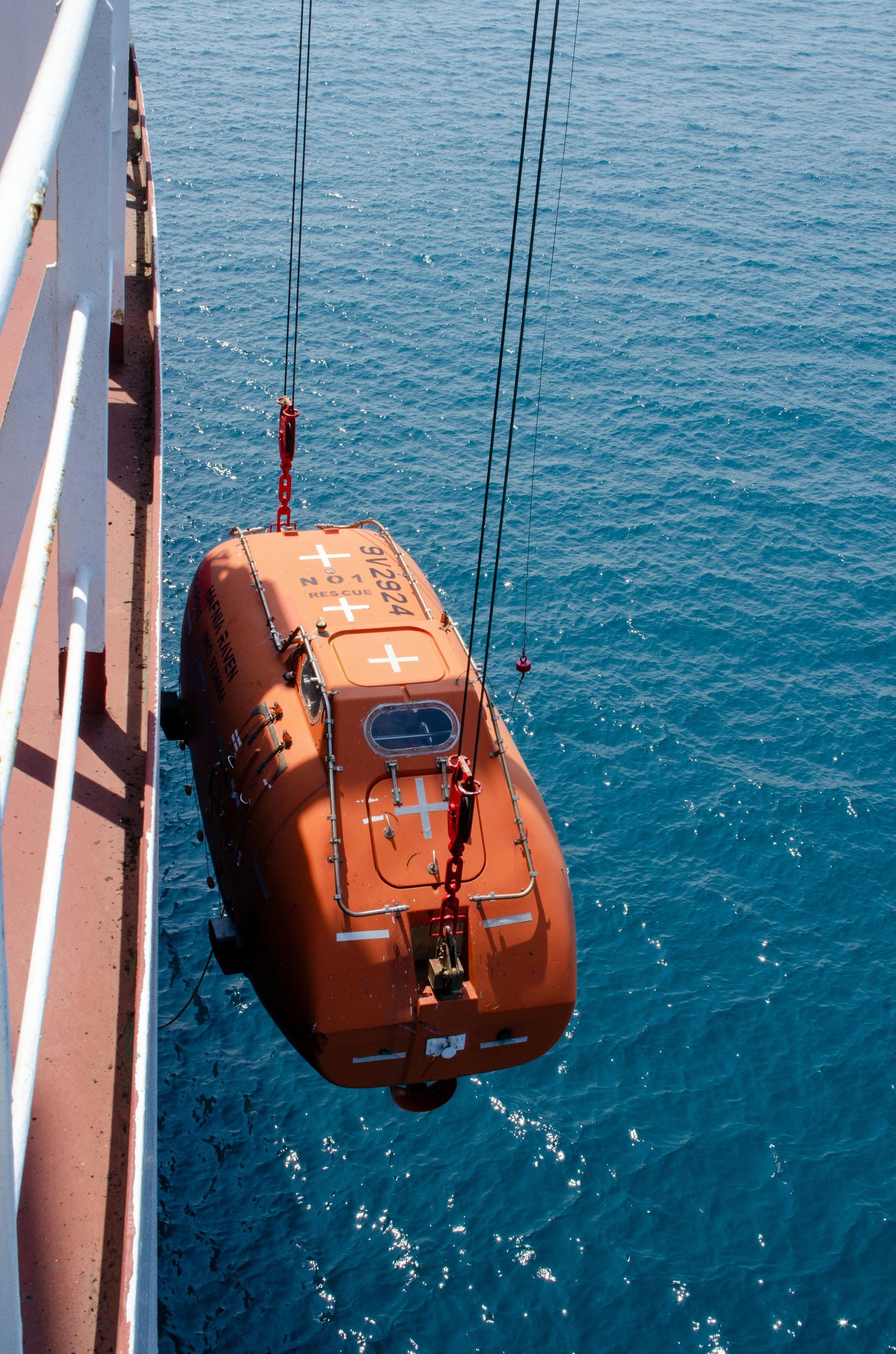 A lifeboat is being lifted out of the water