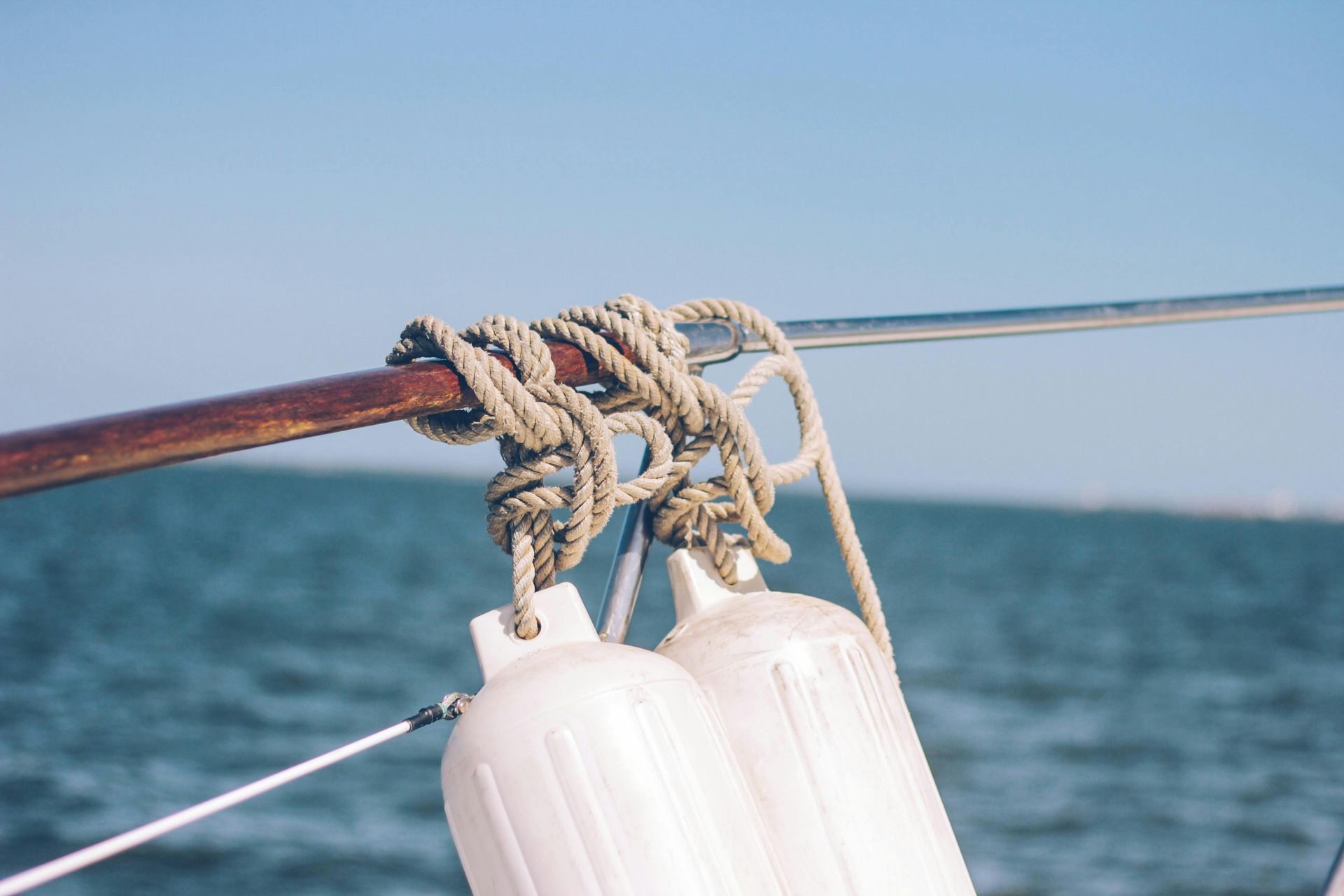 A close up of a boat with a rope and buoys in the water.