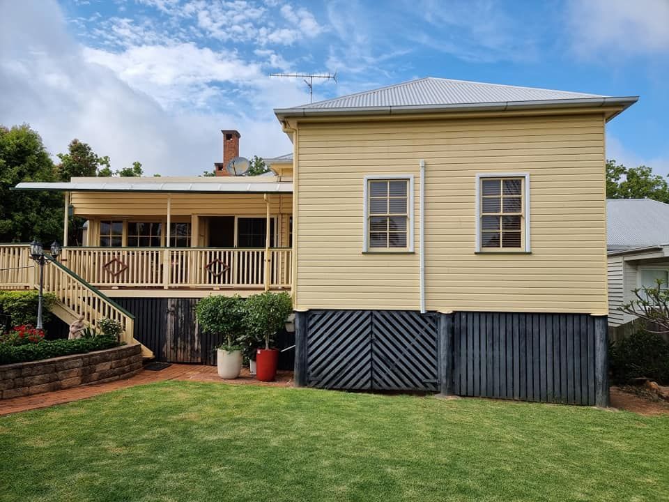 A Yellow House Is Being Restored — LMS Painting & Maintenance Pty Ltd In Charlestown, NSW