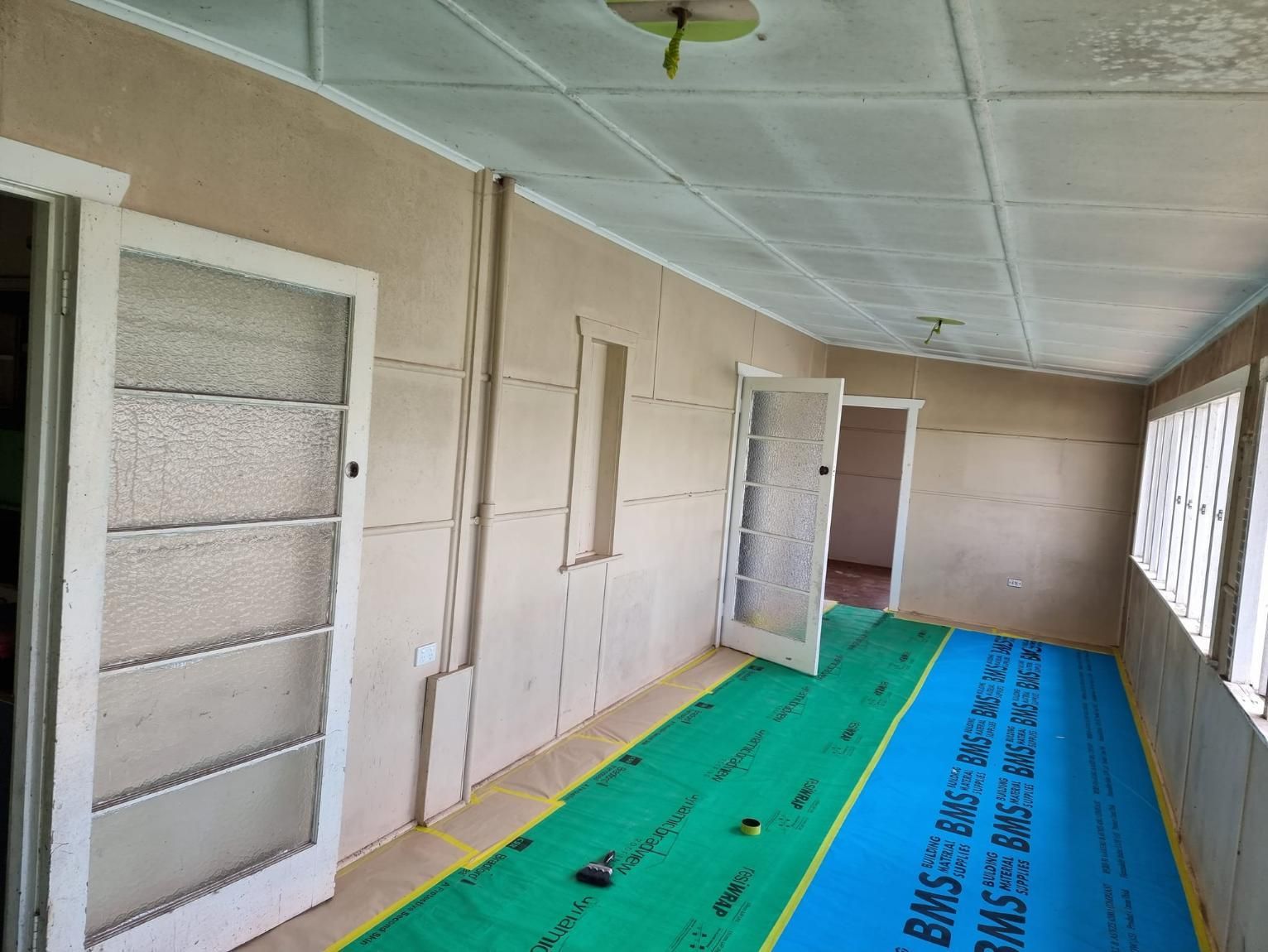 A Room With A Green Mat On The Floor And A Ceiling — LMS Painting & Maintenance Pty Ltd In Charlestown, NSW