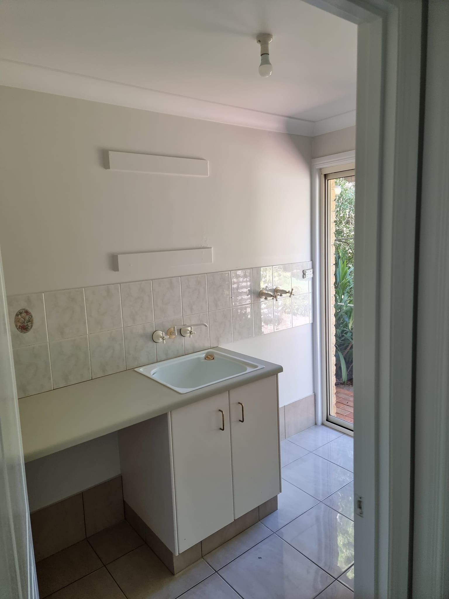 A Kitchen With White Cabinets, A Sink, And A Door — LMS Painting & Maintenance Pty Ltd In Cessnock, NSW