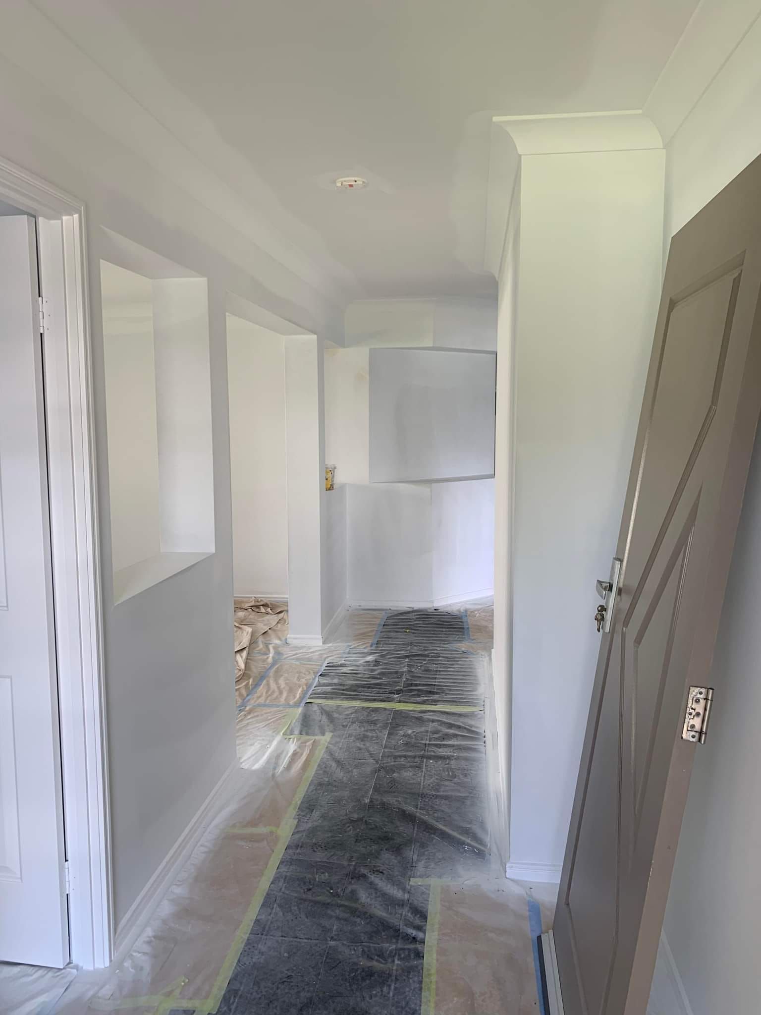 A Hallway With A Carpet On The Floor And A Door — LMS Painting & Maintenance Pty Ltd In Newcastle, NSW