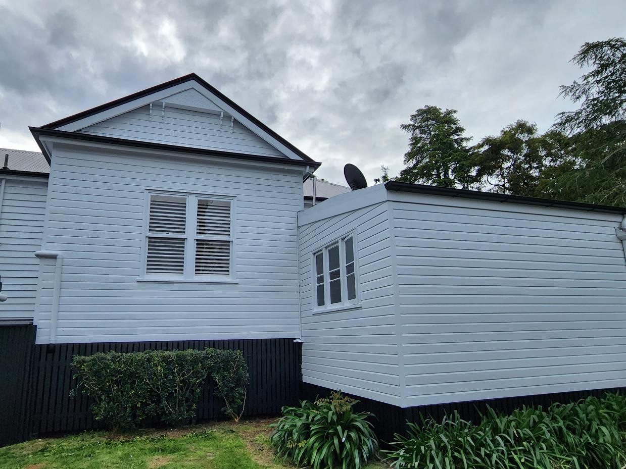 A White House With A Black Fence And A Satellite Dish On The Roof — LMS Painting & Maintenance Pty Ltd In Singleton, NSW