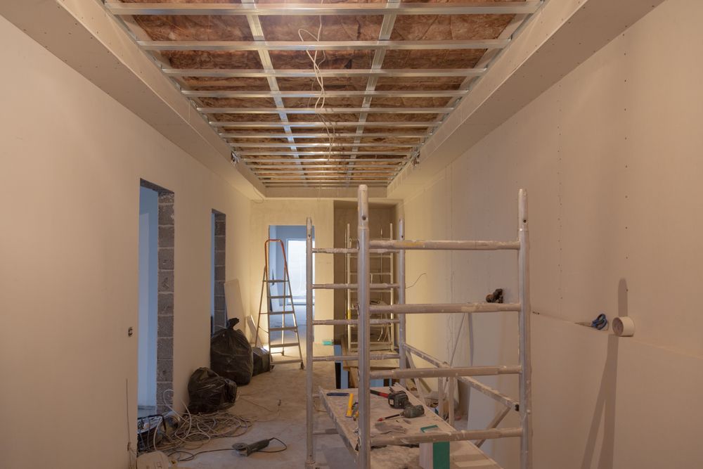 A Hallway Under Construction With Scaffolding And A Ladder — LMS Painting & Maintenance Pty Ltd In Cessnock, NSW
