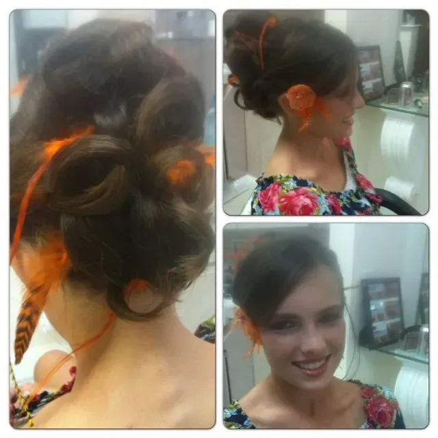 A woman with a bun and orange feathers in her hair