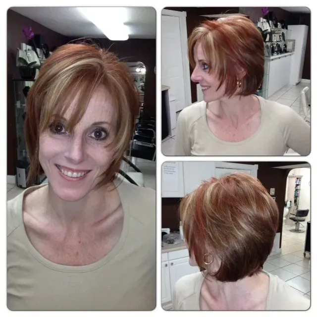 A woman with short red hair is smiling and wearing a tan shirt