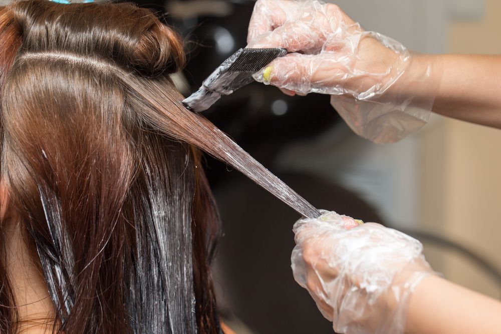 A woman is getting her hair dyed.